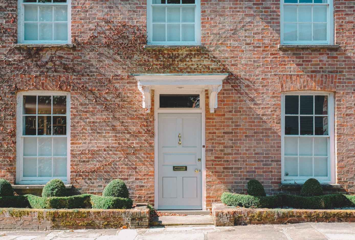 brown and red brick building with a grey wooden door