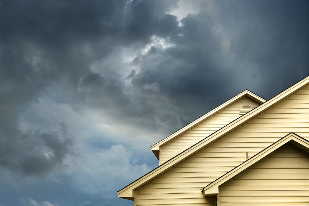 A house under storm clouds requiring buildings insurance