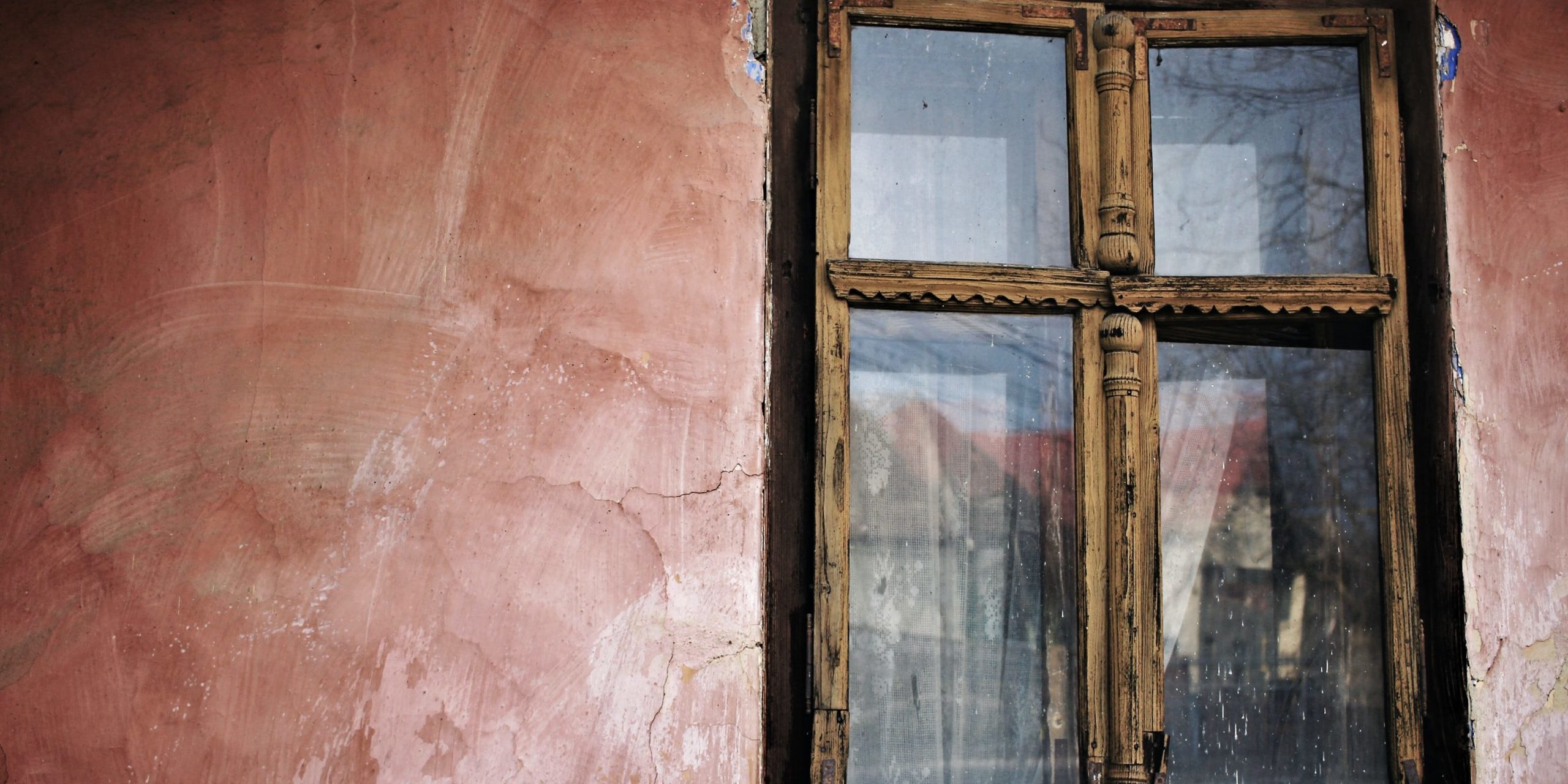 dilapidated wooden window on cracked wall