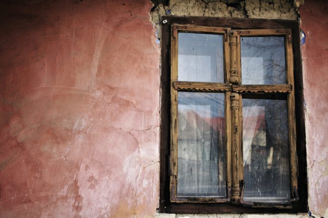 dilapidated wooden window on cracked wall