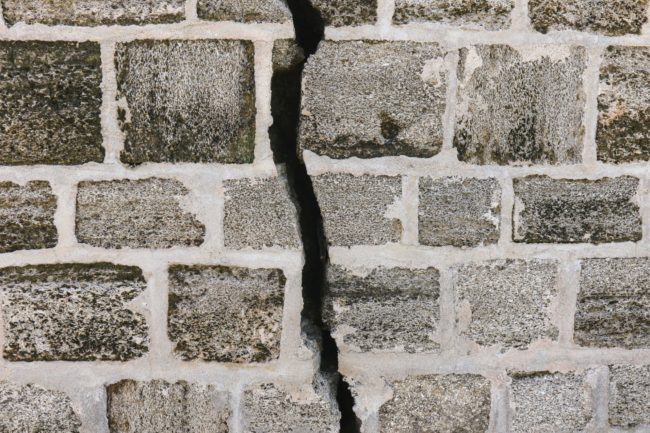 Large crack showing sings of subssidence on grey wall
